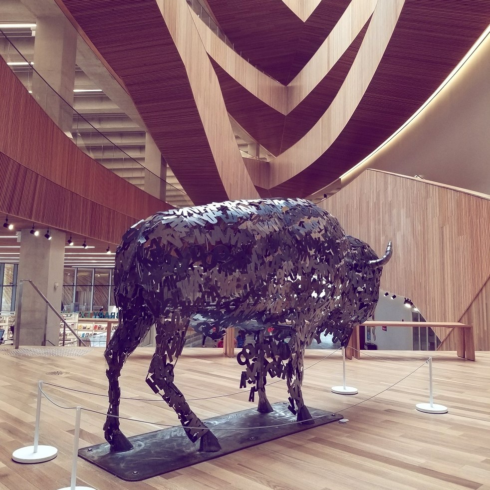 Lionel Peyachew - Photo is a large metallic bison sculpture in the Calgary Central Library