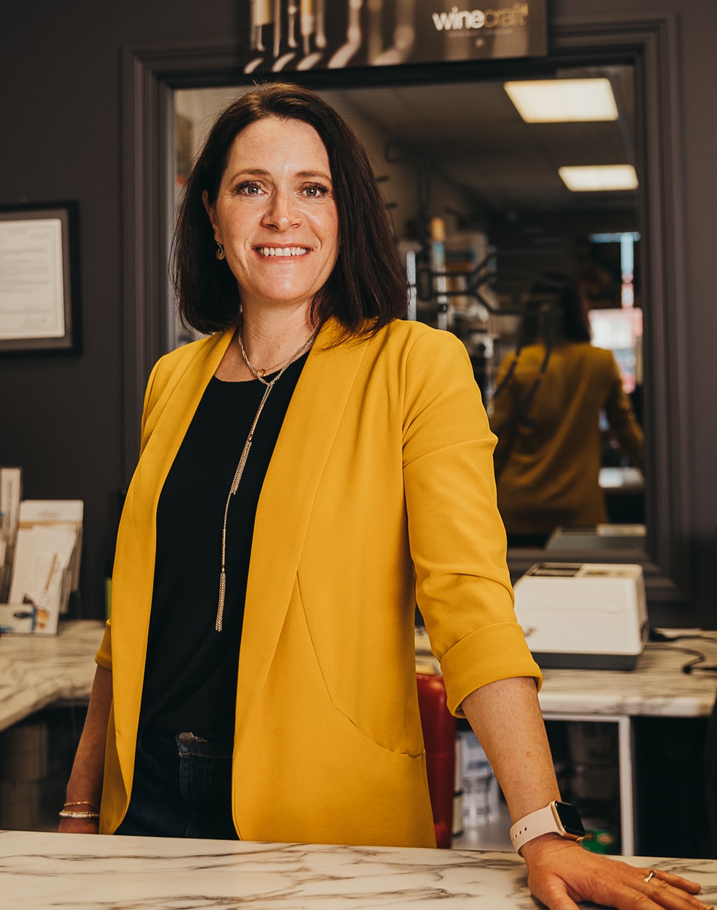 Alison Watson, Saskatchewan business owner - Portrait of woman in short bob smiling and wearing a mustard coloured blazer and black blouse