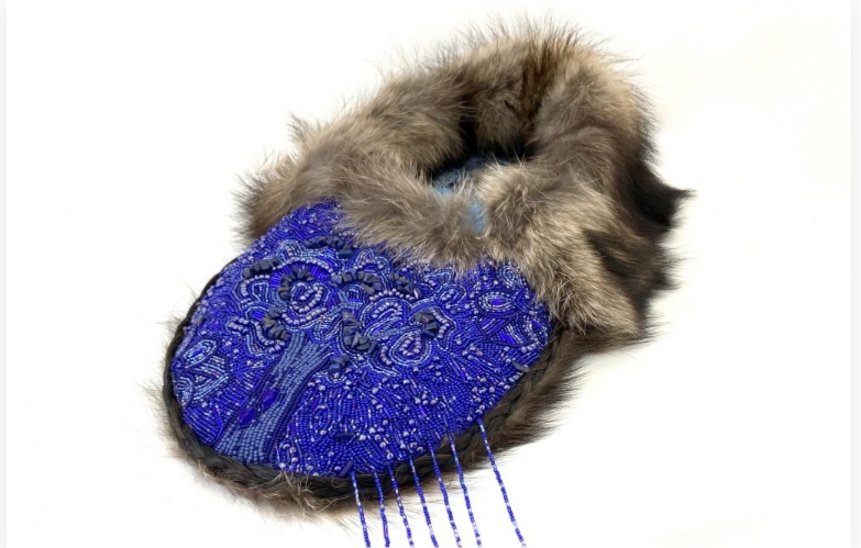 A beaded blue mocassin with brown fur.
