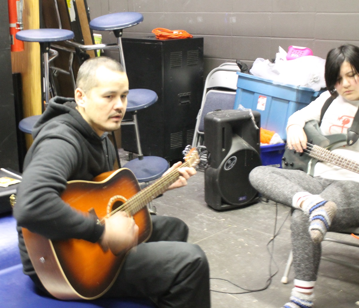 Damien Cheecham teaches students guitar.