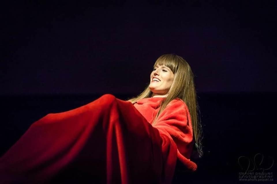Natasha Urkow covered in a red blanket during one of her performances with Listen to Dis'.