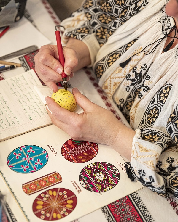 A woman decorating a Ukrainian Easter egg.