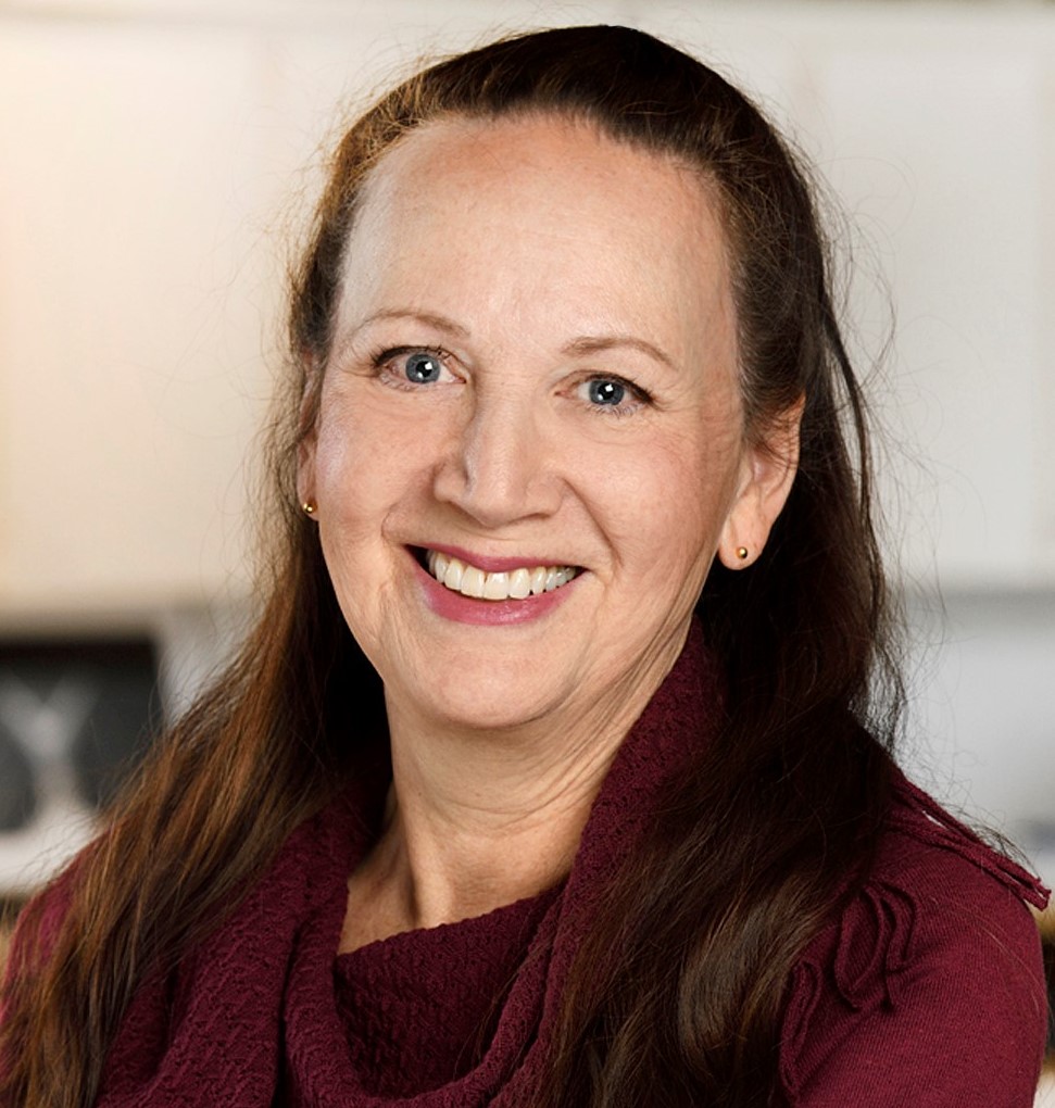 Carol Greyeyes, Policy and Planning Advisor - Indigenous woman with long hair smiling. She is wearing a red blouse.