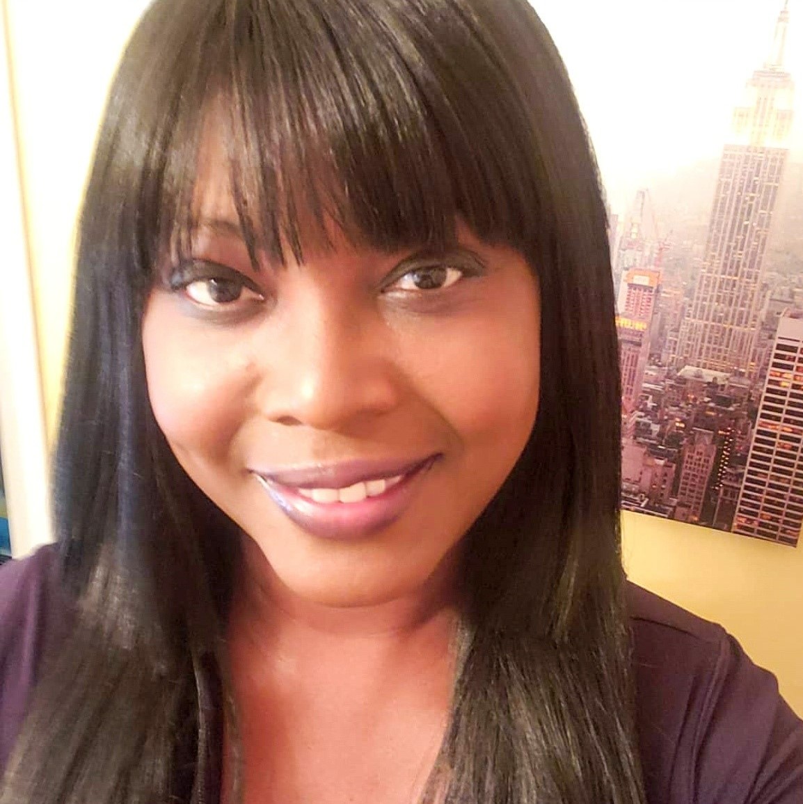 Ingrid D. Johnson - Up close portrait shot of black woman with bangs and long black hair smiling