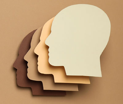 Picture of four monochromatic brown heads overlapping abstract head silhouettes on a background. SK Arts Accessibility Plan to achieve accessibility in the arts.