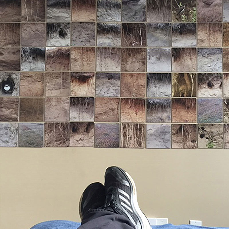 Linda Duvall - Photo of partial artwork with feet wearing sneakers on a table